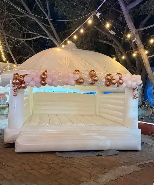 Brincolín blanco decorado para una celebración al aire libre